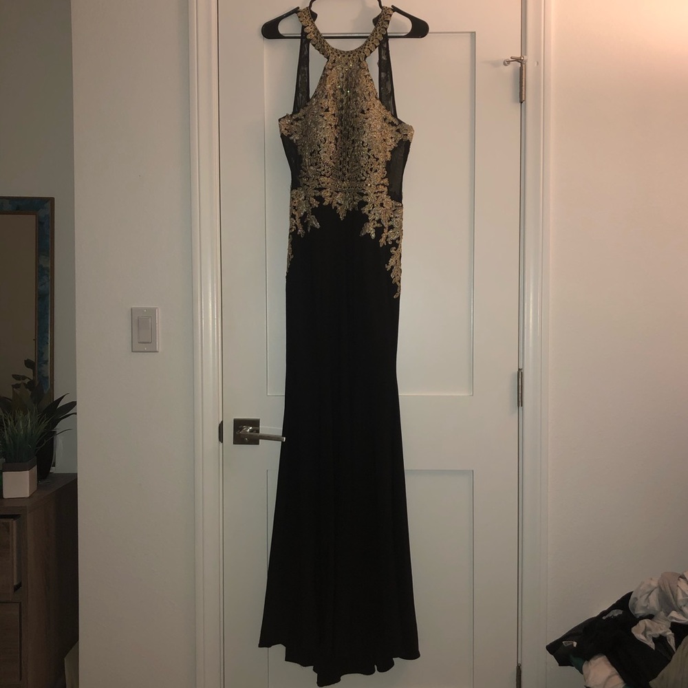 Black floor length dress with gold detail.